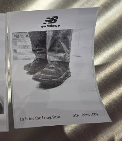 브랜드 로고와 In it for the Long Run 문구, 기록 표기가 들어간 흑백 인화물
